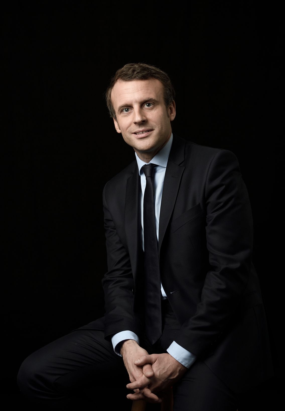 Emmanuel Macron assis, avec une expression pleine de panache.